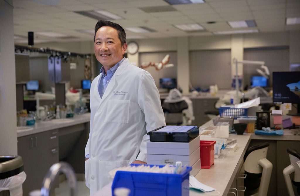 Tung Nguyen, DMD, standing in a lab setting (Photo by Megan May)